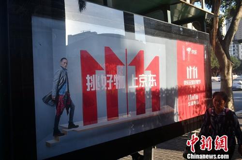資料圖：11月1日，福州民眾從雙十一廣告牌前經(jīng)過。中新社記者 呂明 攝
