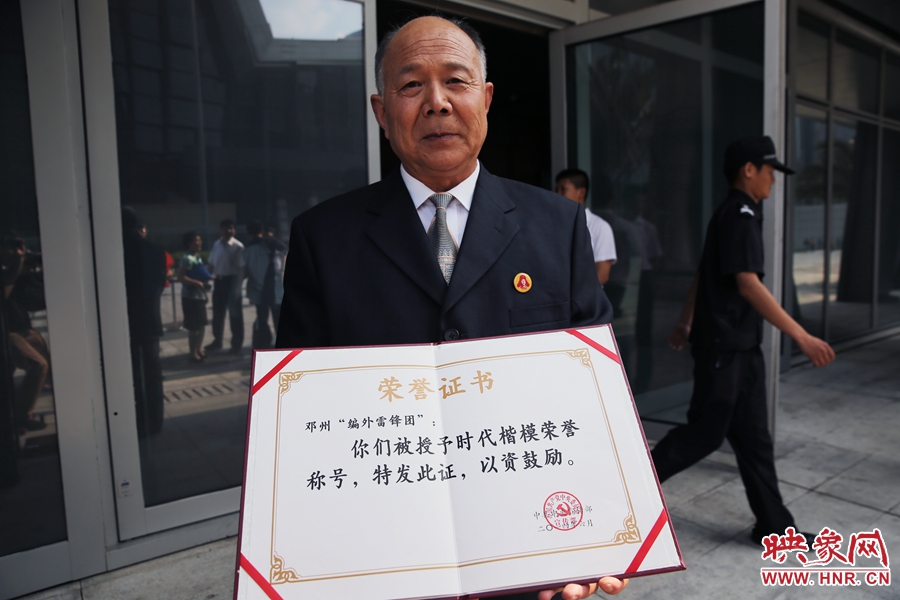 河南鄧州“編外雷鋒團(tuán)”團(tuán)長宋清梅向眾多記者展示中宣部授予的“時(shí)代楷?！睒s譽(yù)證書。