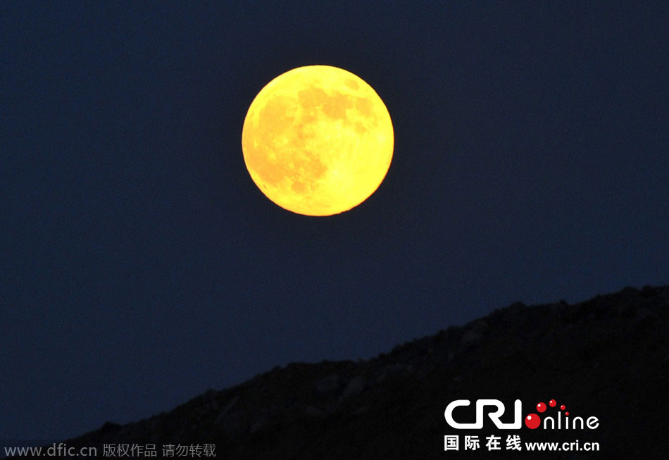 8月10日晚，一輪金燦燦的大月亮在遼寧省大連市東方升起。圖片來源：劉德斌/東方IC