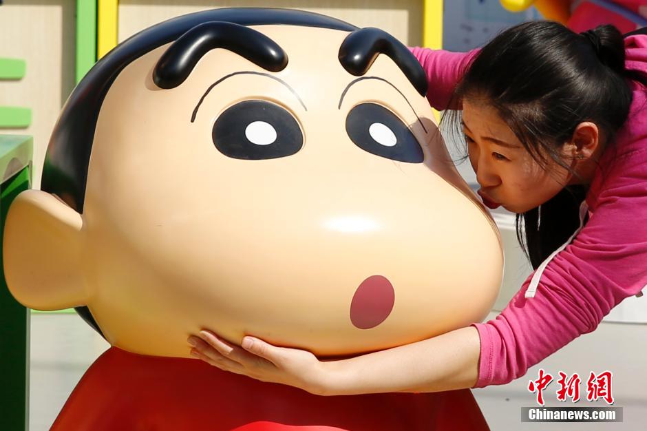 4月22日，游客與蠟筆小新合影?！跋灩P小新25周年紀(jì)念特展”日前在北京開展，吸引了不少市民游客。