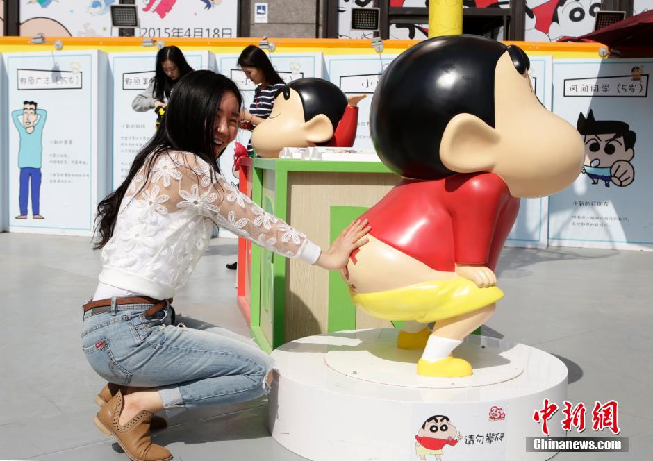 4月22日，游客與蠟筆小新合影?！跋灩P小新25周年紀(jì)念特展”日前在北京開展，吸引了不少市民游客。