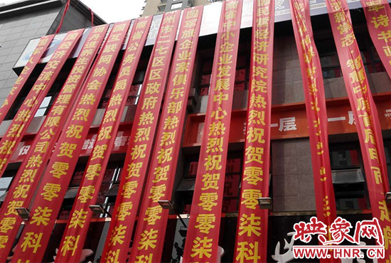 路邊一棟樓上懸掛著二三十條紅色條幅，全部是祝賀一家公司開(kāi)業(yè)的。
