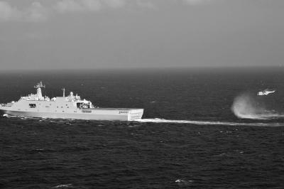 11日，抵達馬航飛機失聯(lián)海區(qū)的海軍井岡山艦與艦載直升機協(xié)同展開立體搜救行動。新華社發(fā)
