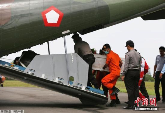 資料圖：當?shù)貢r間2015年1月19日，印尼龐卡蘭布翁，依斯干達空軍基地，救援隊成員正將裝有亞航失事飛機遇難者尸體的棺材抬上一架CN2950運輸機。