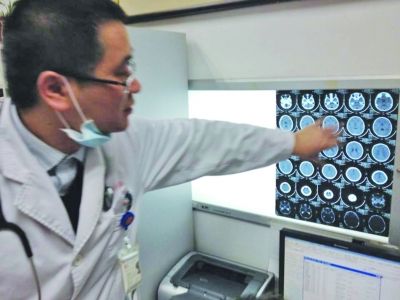 醫(yī)生在查看男孩的腦部CT片。薛馬義 攝
