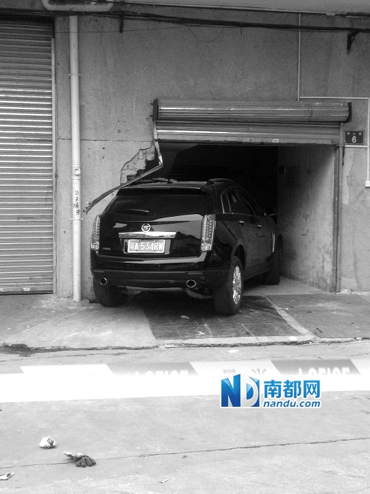 　昨日，凱迪拉克撞人后停在一倉(cāng)庫(kù)門(mén)口，車(chē)后有一攤血跡。 南都記者陳杰生攝