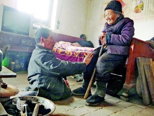52歲的劉蘭山每天靠爬行照顧90歲的老母親。孫國(guó)祥 攝