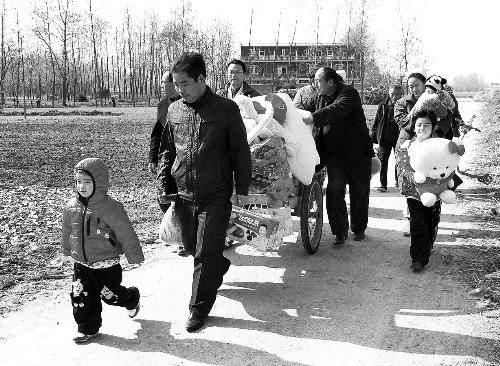 姐（左一）弟（右一護(hù)士懷中男嬰）返鄉(xiāng)，愛(ài)心捐贈(zèng)滿滿一架子車。