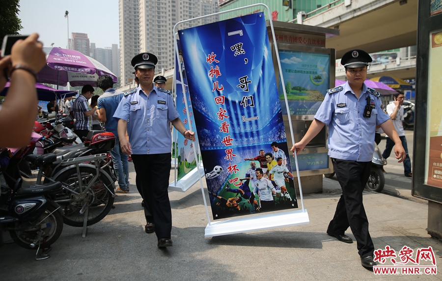 7月2日上午，鄭州市紫荊山地鐵站出入口，執(zhí)法人員抬著寫有勸導(dǎo)語(yǔ)的宣傳板，前往占道經(jīng)營(yíng)攤位“圍觀執(zhí)法”