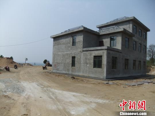 鴨河水庫(kù)庫(kù)區(qū)邊的新建別墅，一面墻上寫(xiě)著“拆”，另一邊在加緊施工。吳揚(yáng)　攝