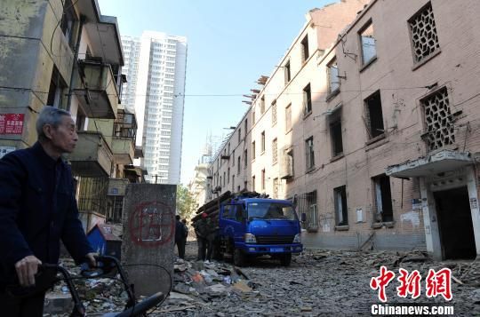 一位花甲老人站在即將拆除的樓房旁，默默地與“蘇聯(lián)樓”告別?！〉杂鸺选z